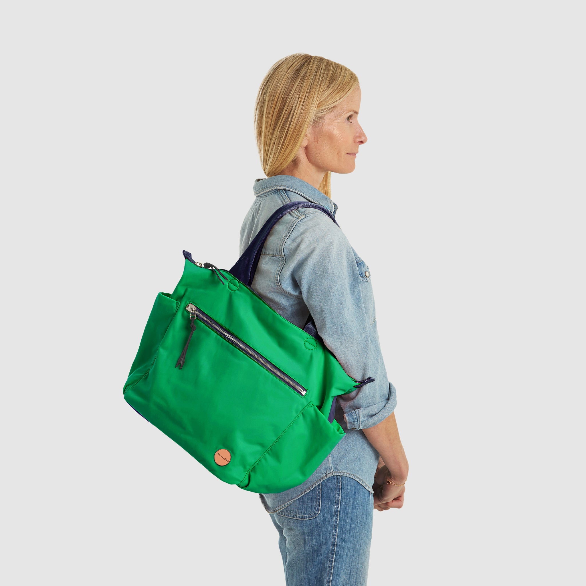 shortyLOVE tillie tote bag in grass green/navy; on model in jean top and jeans against white background.