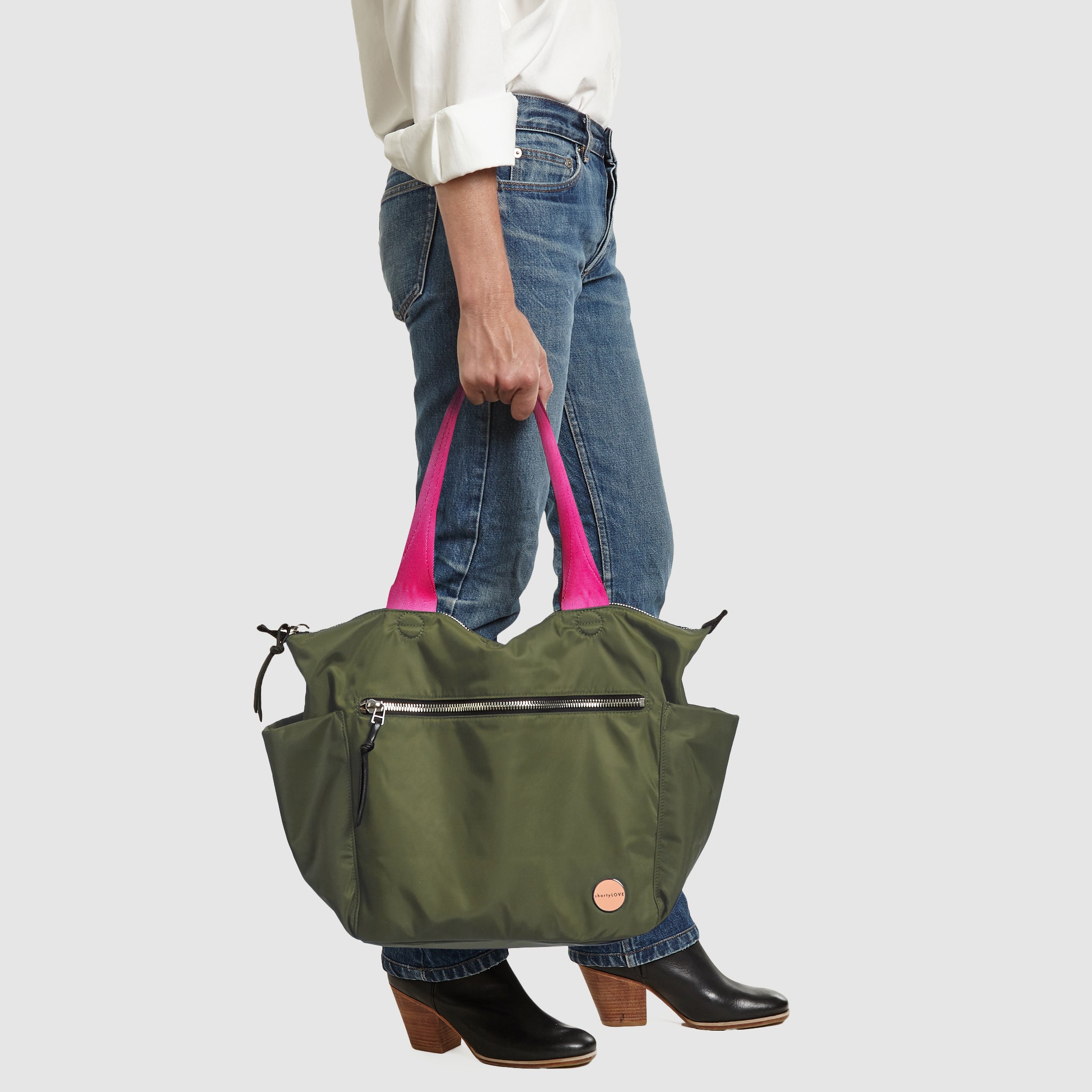 shortyLOVE tillie tote bag in army green; in hand of model in white button down shirt and jeans against white background.
