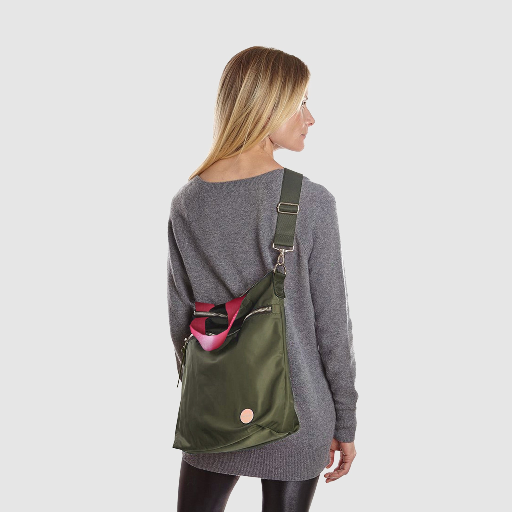 shortyLOVE wonder large crossbody/messenger bag in army green; on model in grey long sleeve sweater and black leggings against white background.