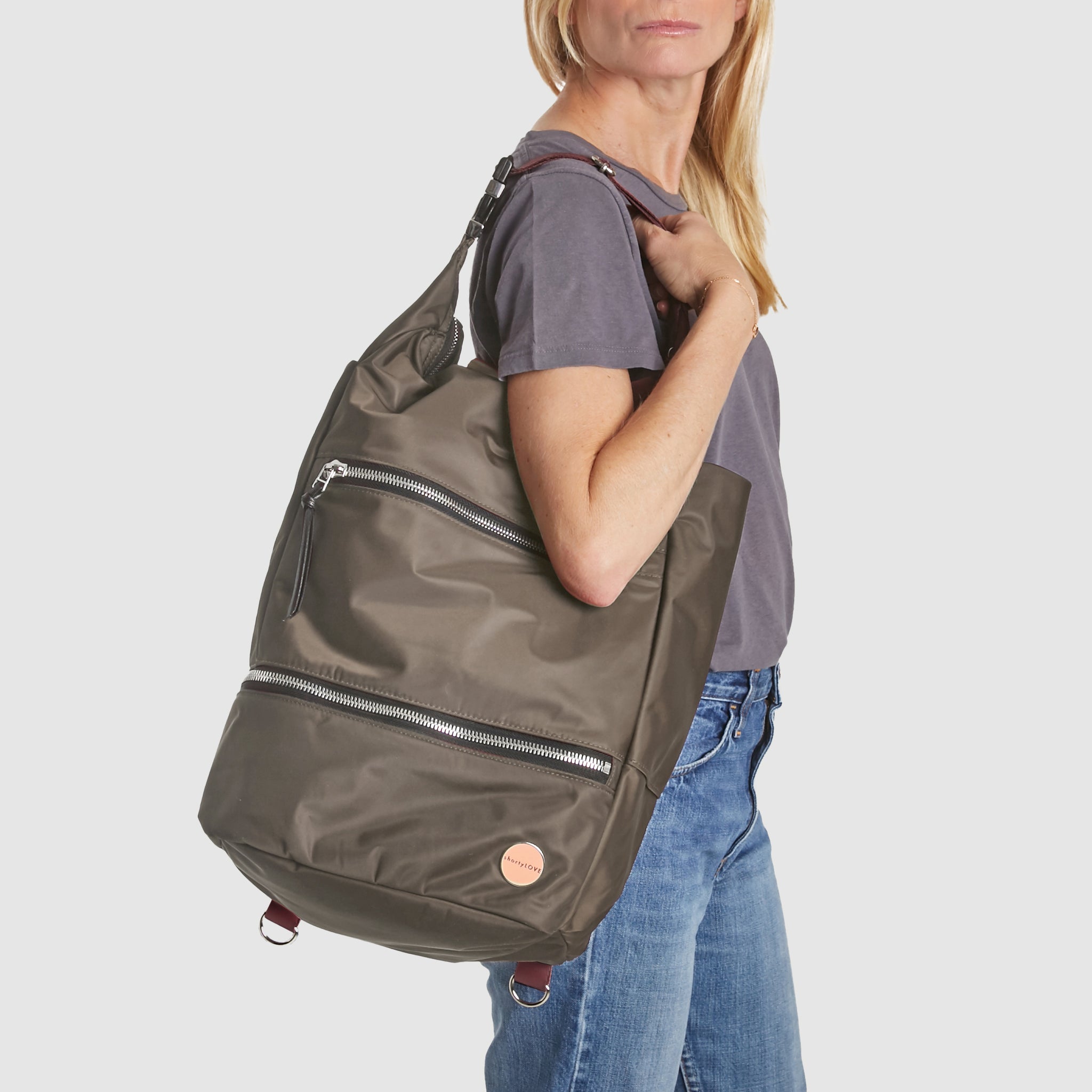 shortyLOVE boxer backpack in mocha; over shoulder of model in grey t-shirt and jeans against white background.