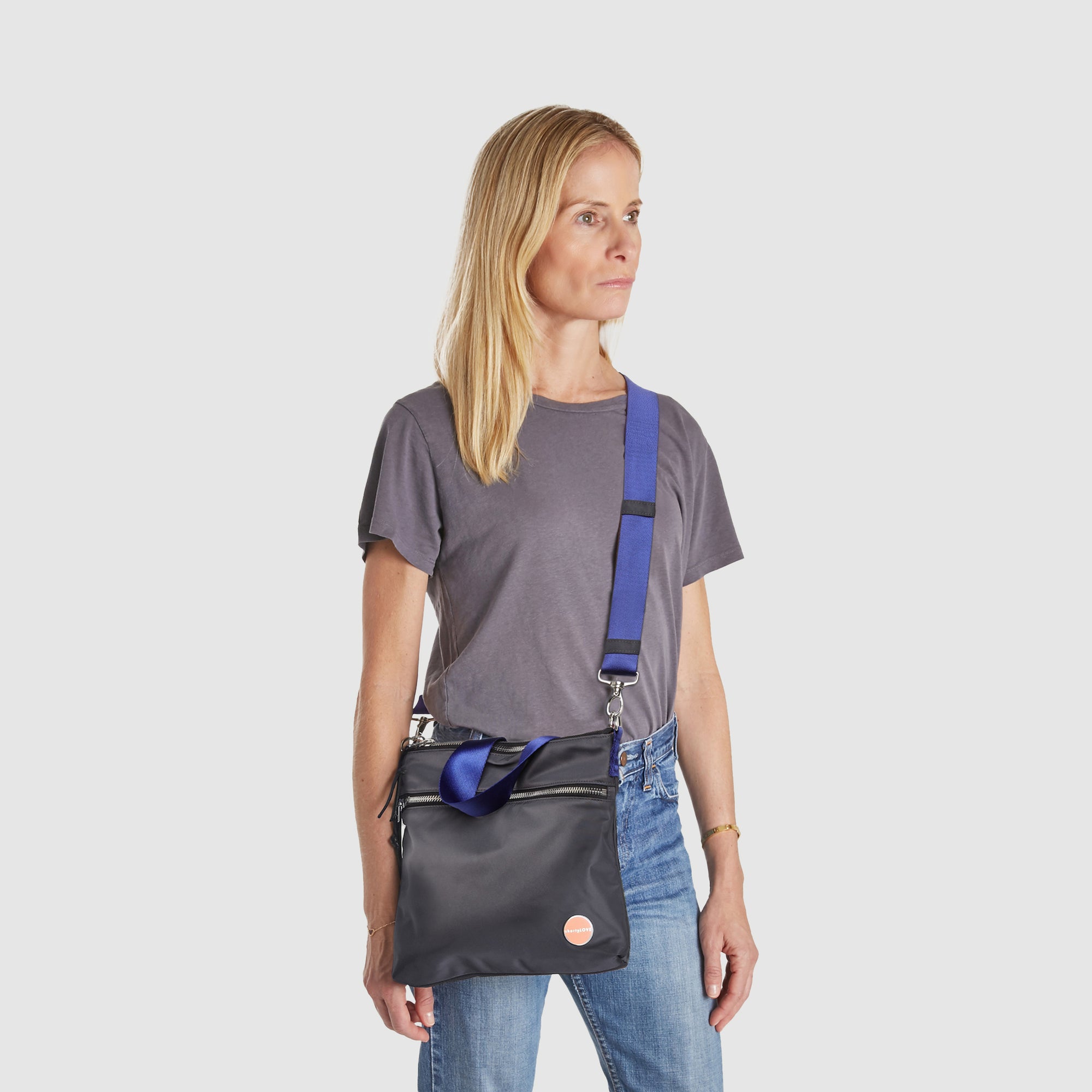 shortyLOVE amuse medium sized crossbody bag in charcoal; worn crossbody by model.