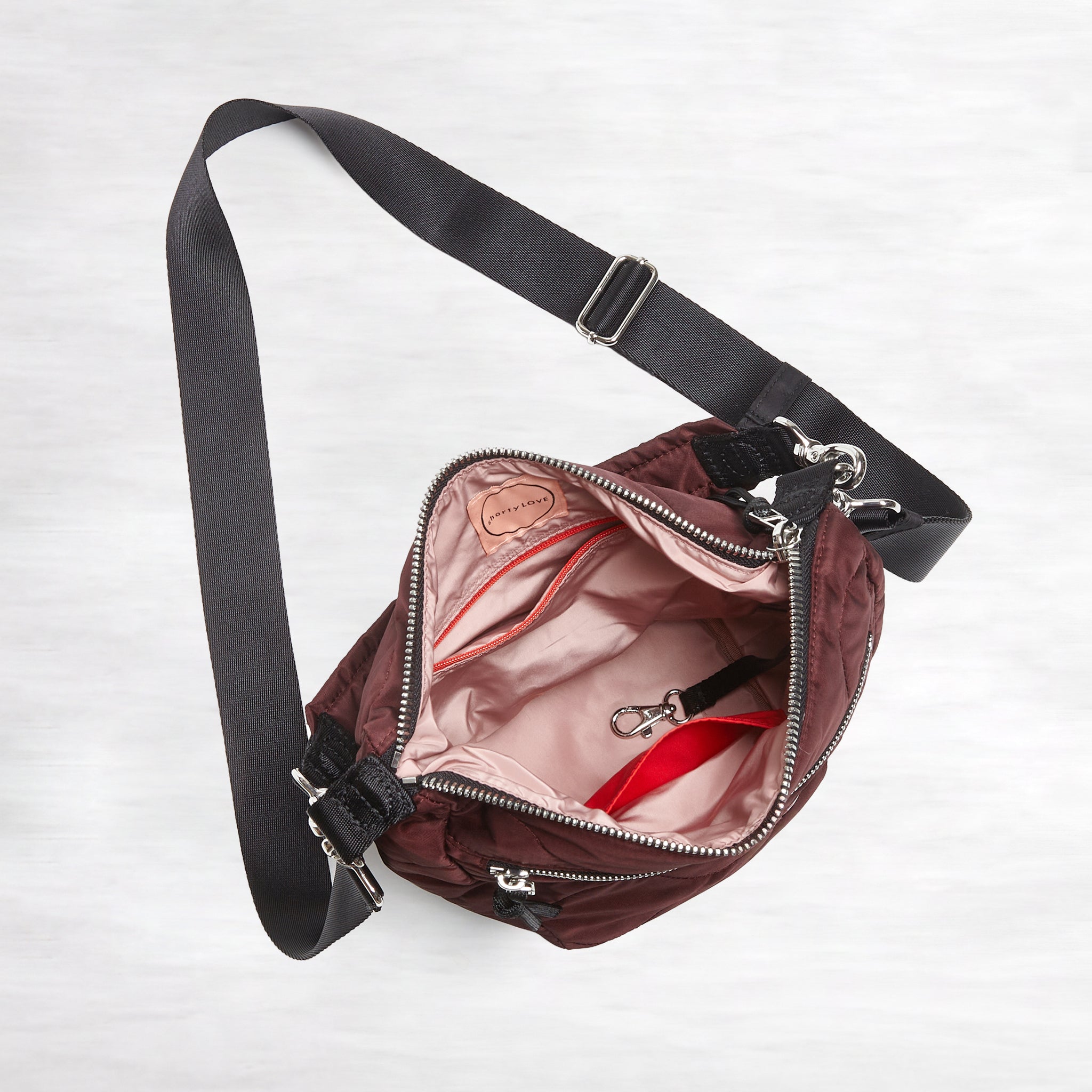 shortyLOVE marcel crossbody bucket bag in bordeaux; top down view against white background.