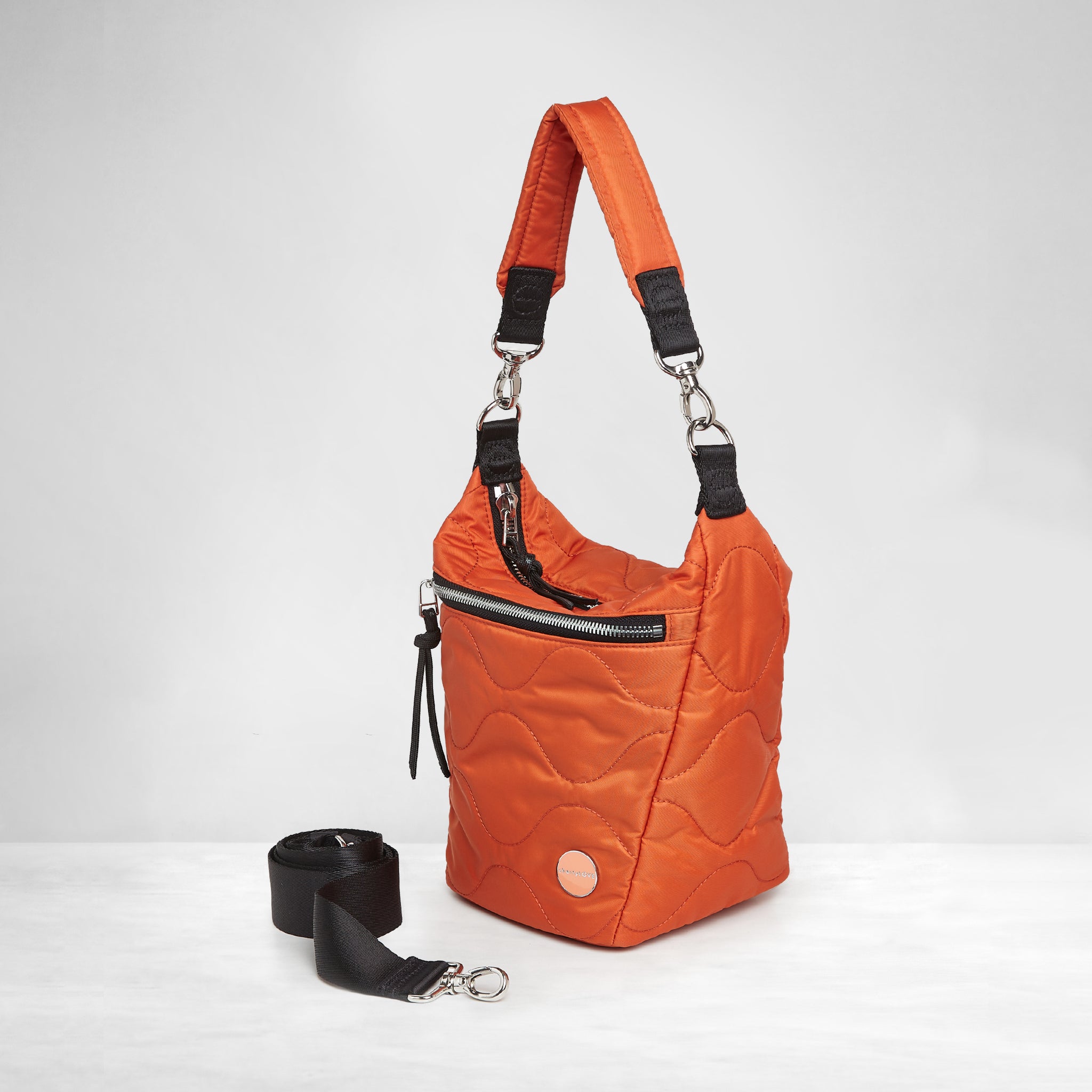 shortyLOVE marcel crossbody bucket bag in orange; side view against white background.