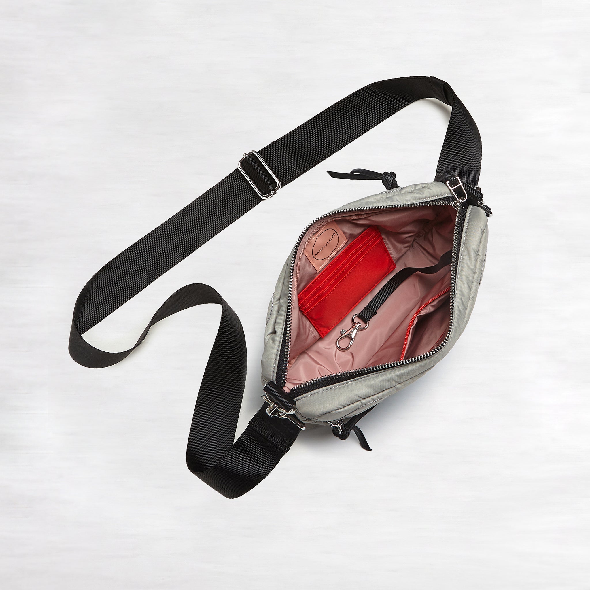 shortyLOVE small cruiser small crossbody bag in milky grey; top-down view showing interior blush lining against white background.