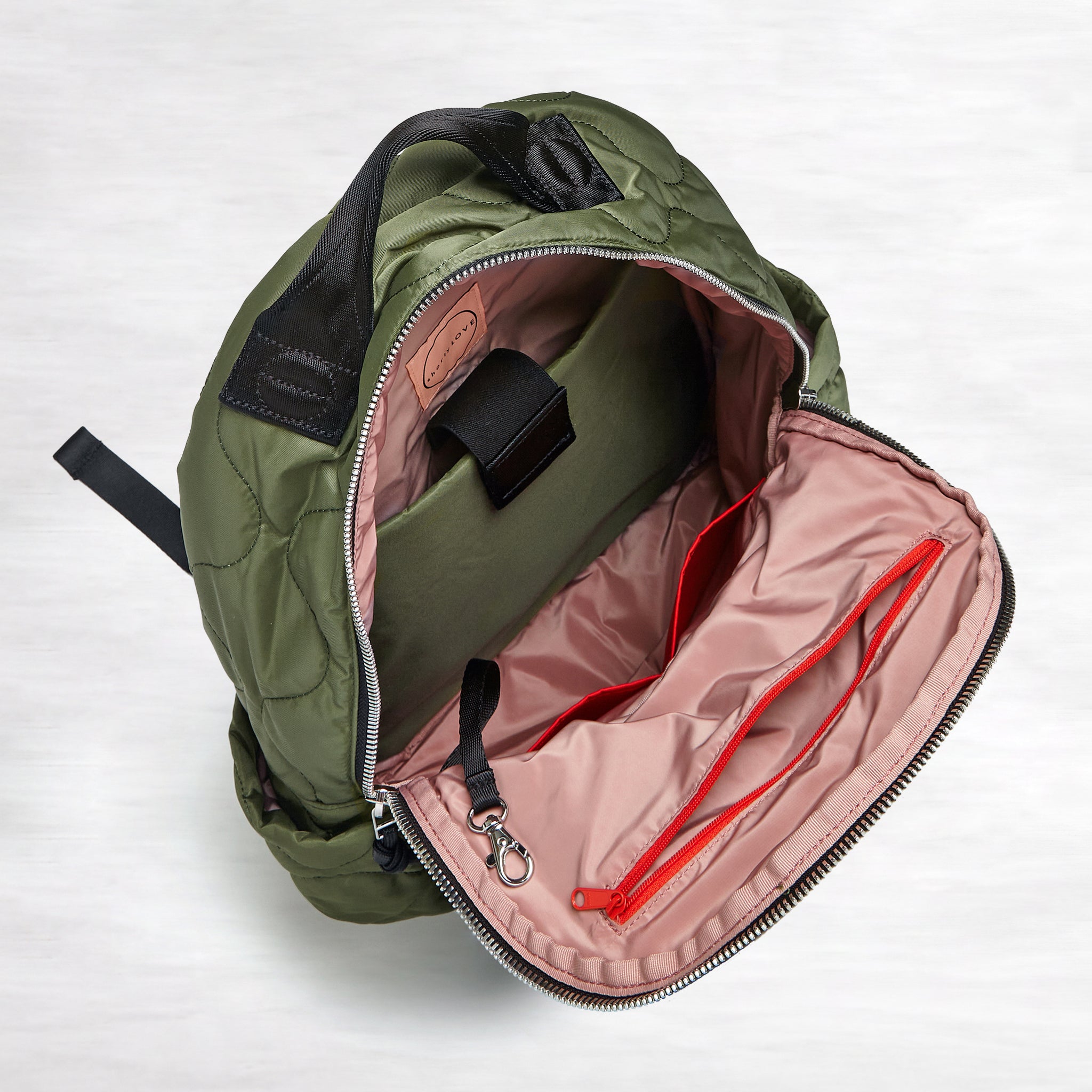 shortyLOVE tate backpack in sage; top-down view showing interior blush lining against white background.