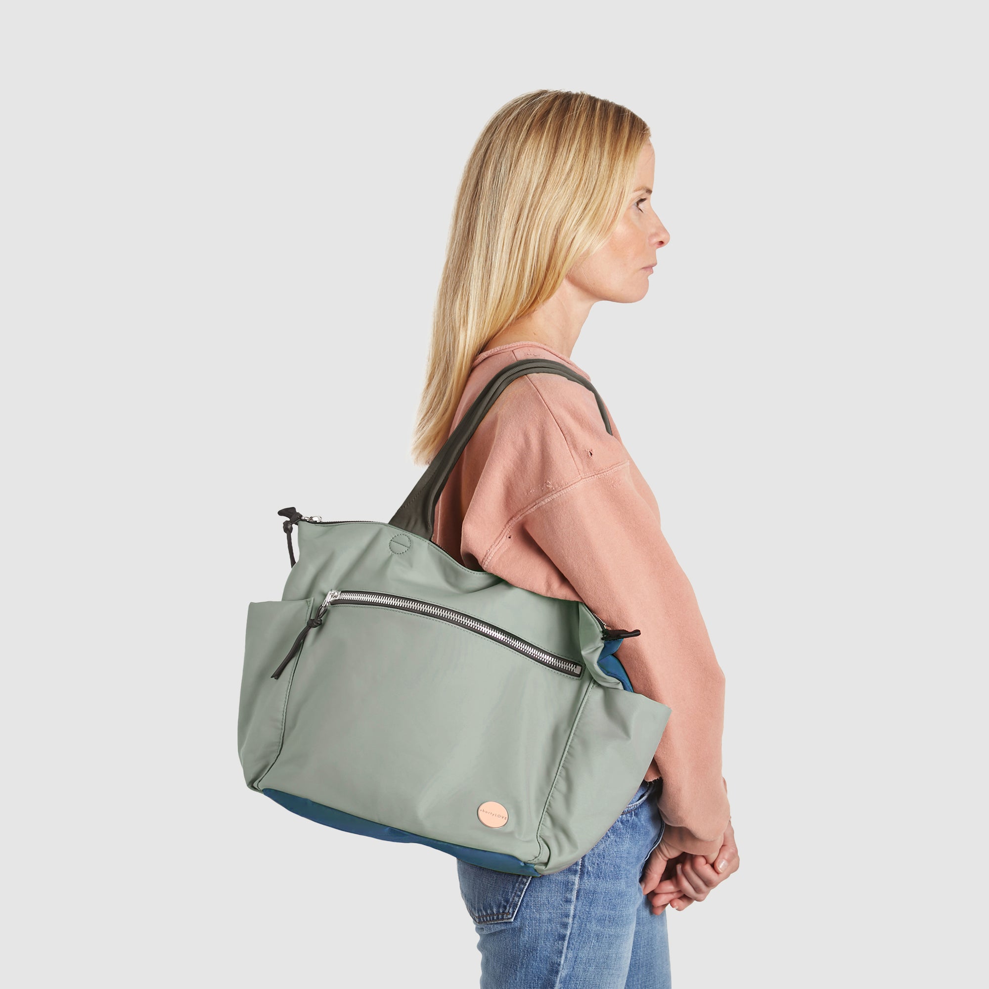 shortyLOVE tillie tote bag in slate/teal on model in jeans against white background.