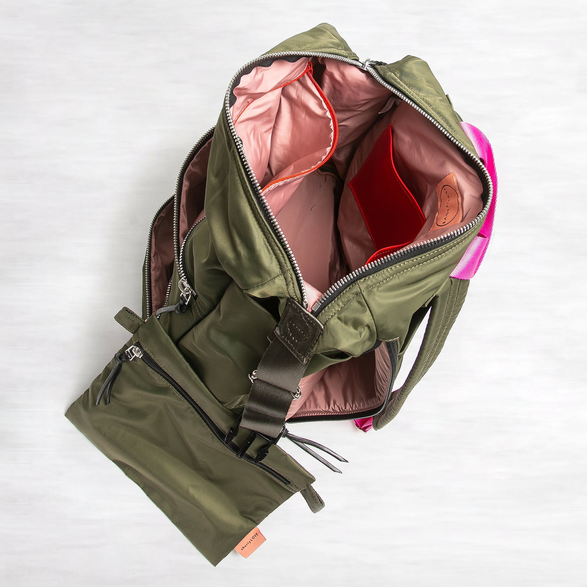shortyLOVE boxer backpack bag in army green; top-down view showing interior pink lining against white background.