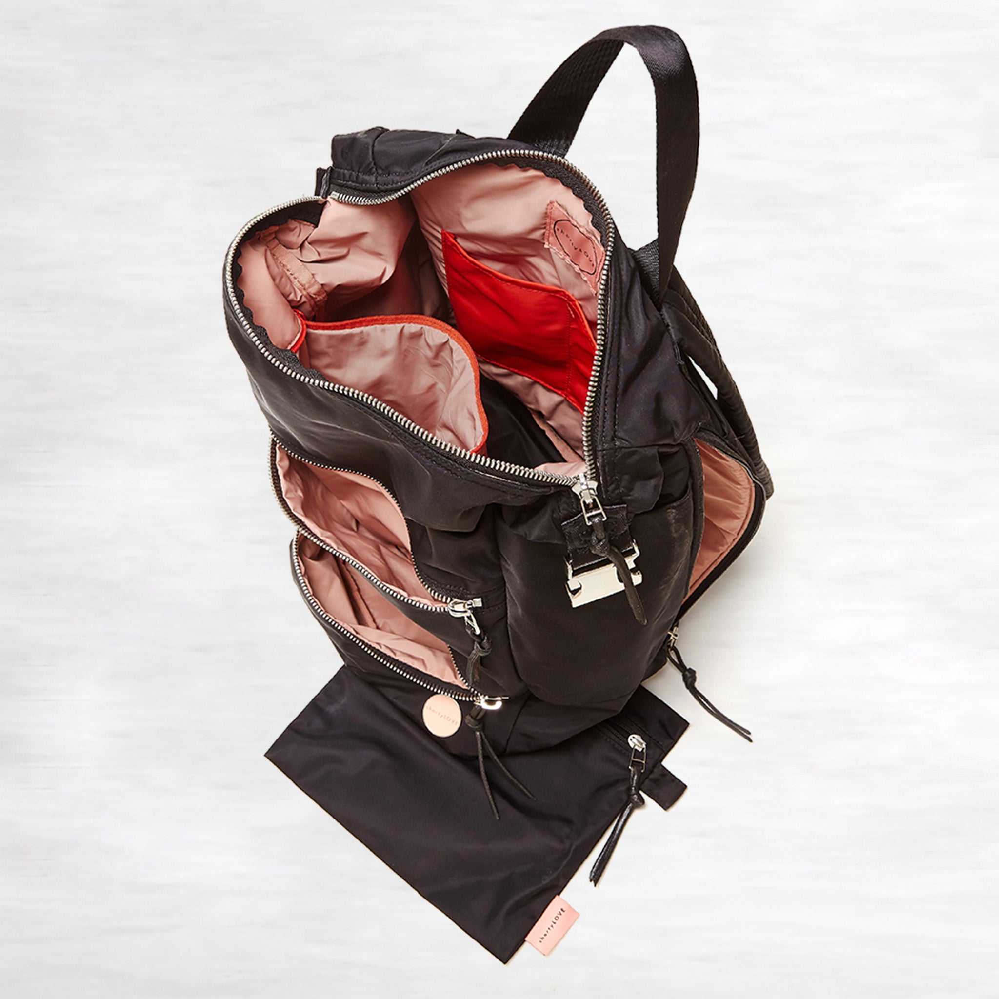shortyLOVE boxer backpack bag in black; top-down view showing interior pink lining against white background.