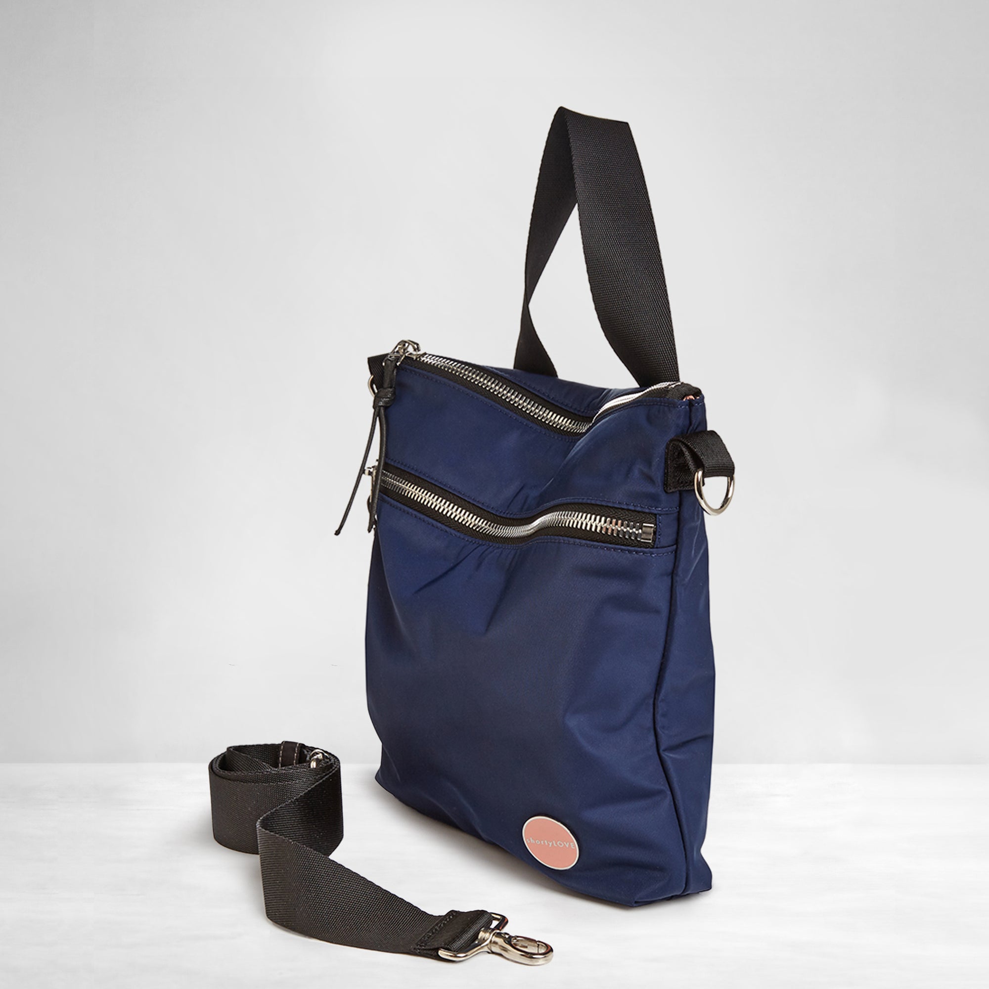 shortyLOVE amuse medium sized crossbody bag in navy; side angle view against white background.