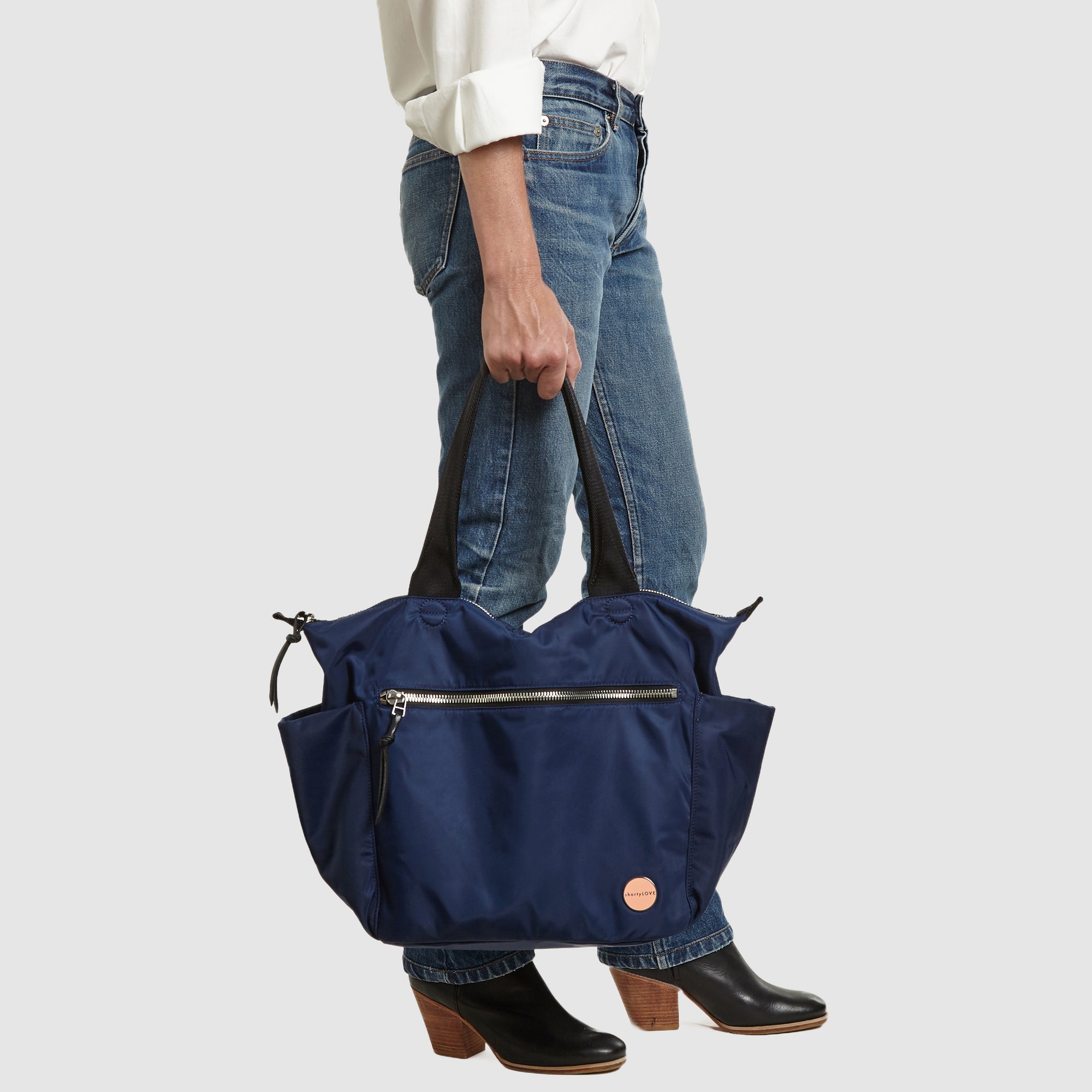 shortyLOVE tillie tote bag in navy; in hand of model in white button down shirt and jeans against white background.