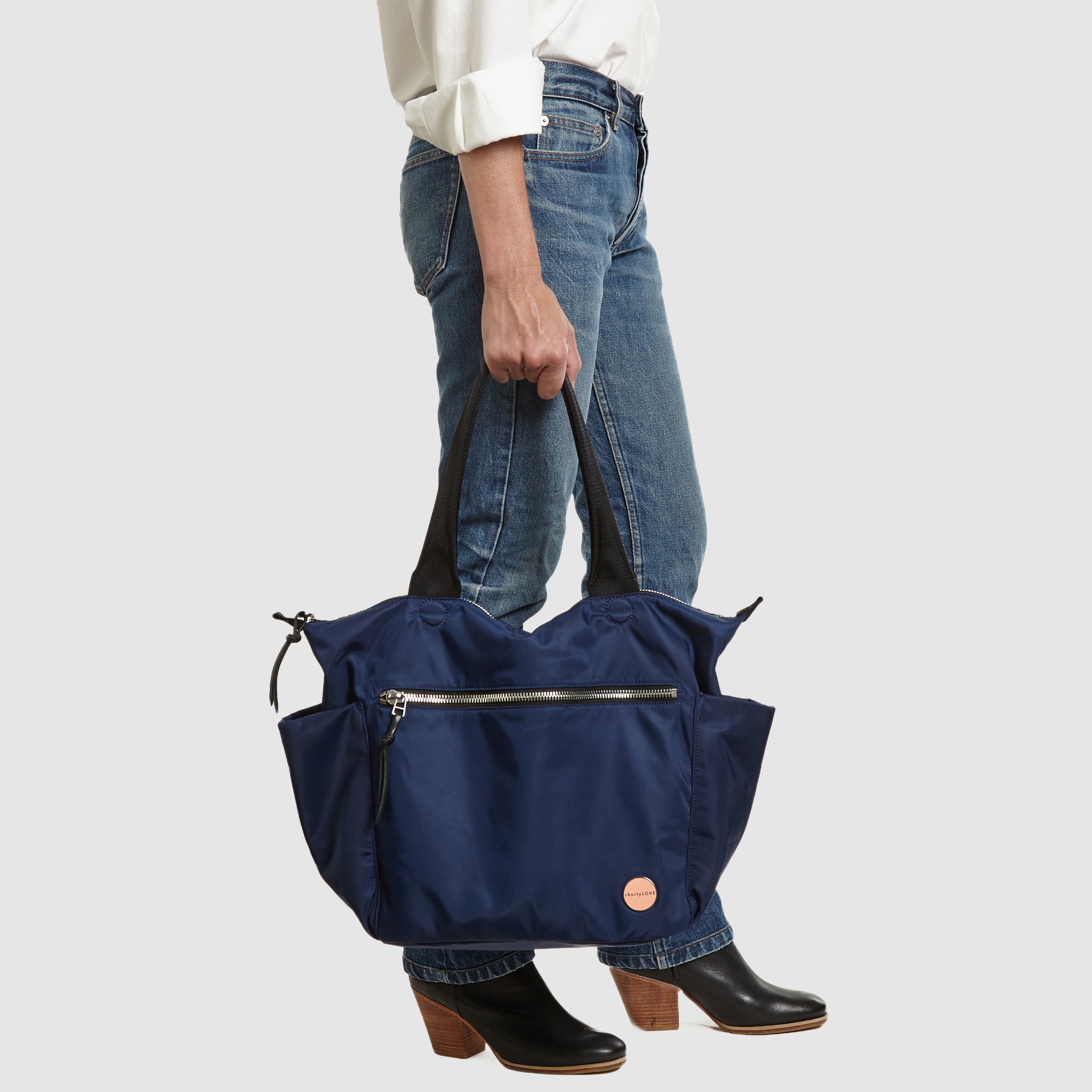 shortyLOVE tillie tote bag in navy; in hand of model in white button down shirt and jeans against white background.