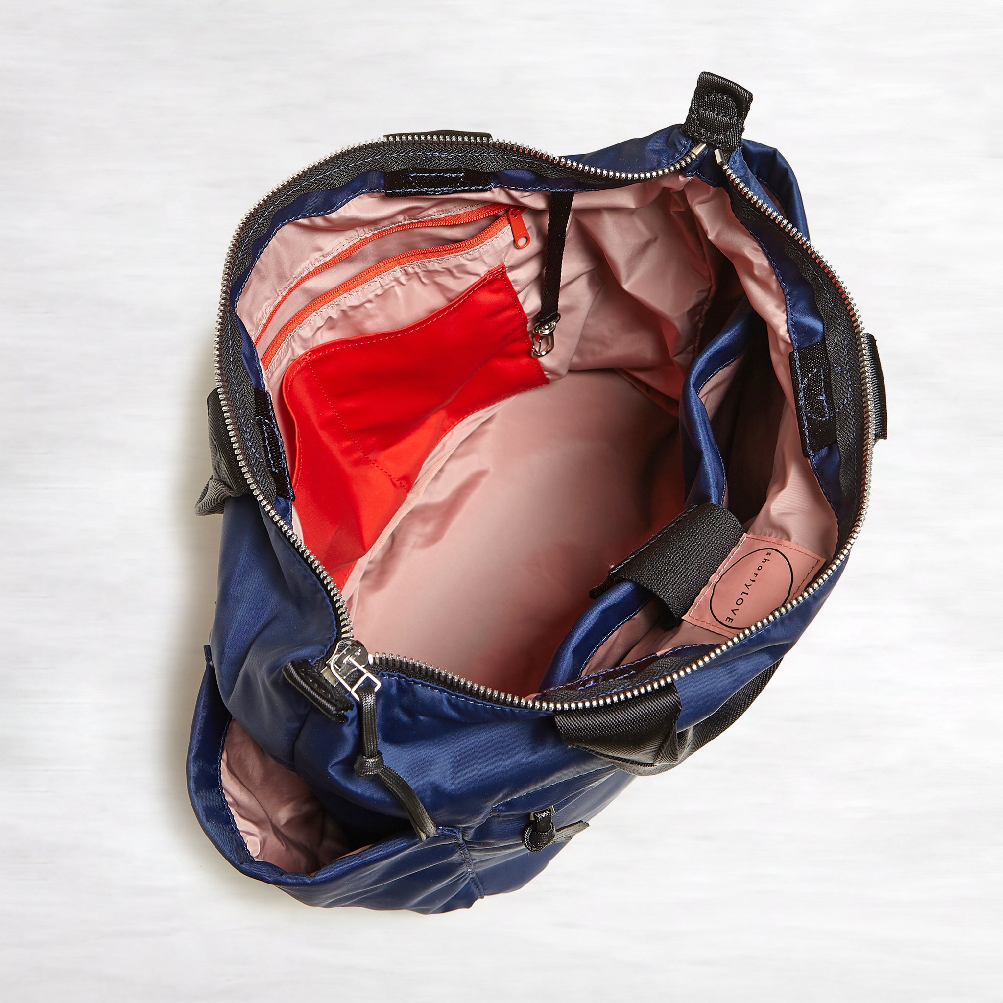 shortyLOVE tillie tote bag in navy; top-down view showing interior pink lining against white background.