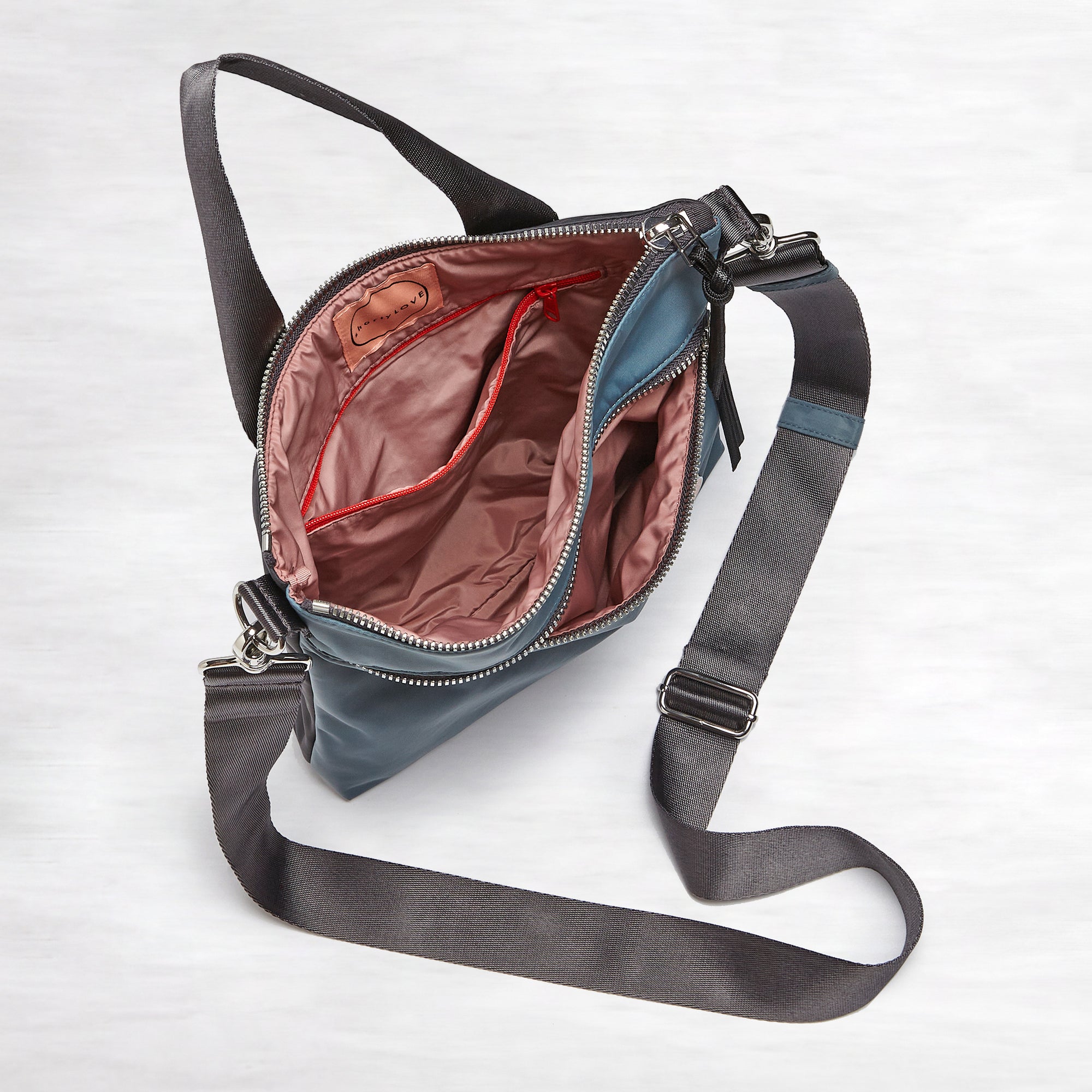 shortyLOVE amuse medium sized crossbody bag in steel blue/charcoal; top-down view showing interior steel blue/charcoal lining against white background.