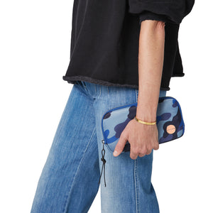 shortyLOVE jetty clutch/wallet in blue camo; hand held by model in black sweatshirt and jeans against white background.