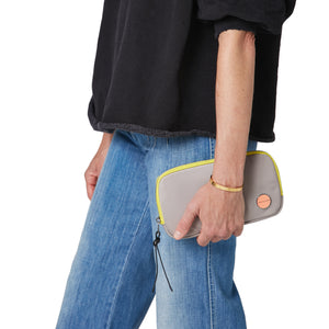 shortyLOVE jetty clutch/wallet in grey; hand held by model in jeans against white background.