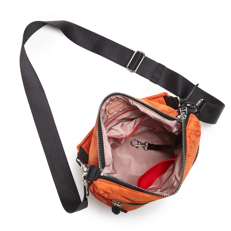 shortyLOVE marcel crossbody bucket bag in orange; top-down view showing interior blush lining against white background.