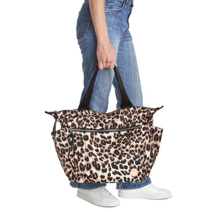 shortyLOVE tillie tote bag in leopard; hand held by model in jeans against white background.