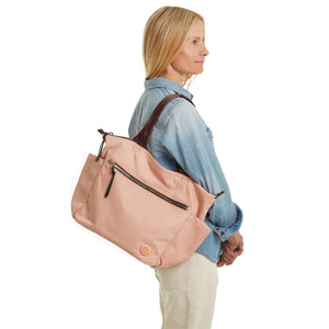 shortyLOVE tillie tote bag in dusty peach; on model in jean top and white jeans against white background.