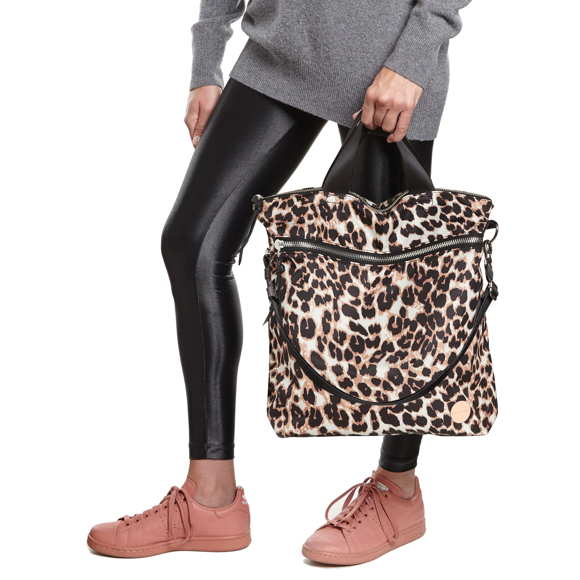 shortyLOVE wonder large crossbody/messenger bag in leopard; hand held by model in black leggings against white background. 