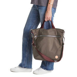 shortyLOVE wonder large crossbody/messenger bag in mocha; hand held by model in jeans against white background.
