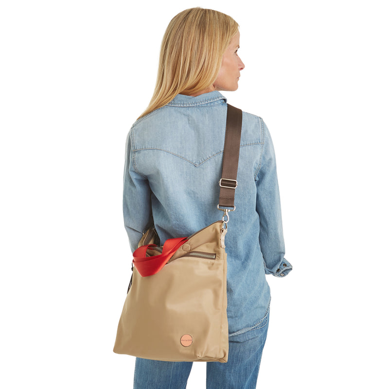 shortyLOVE wonder large crossbody/messenger bag in khaki; on model in jean top and jeans against white background.