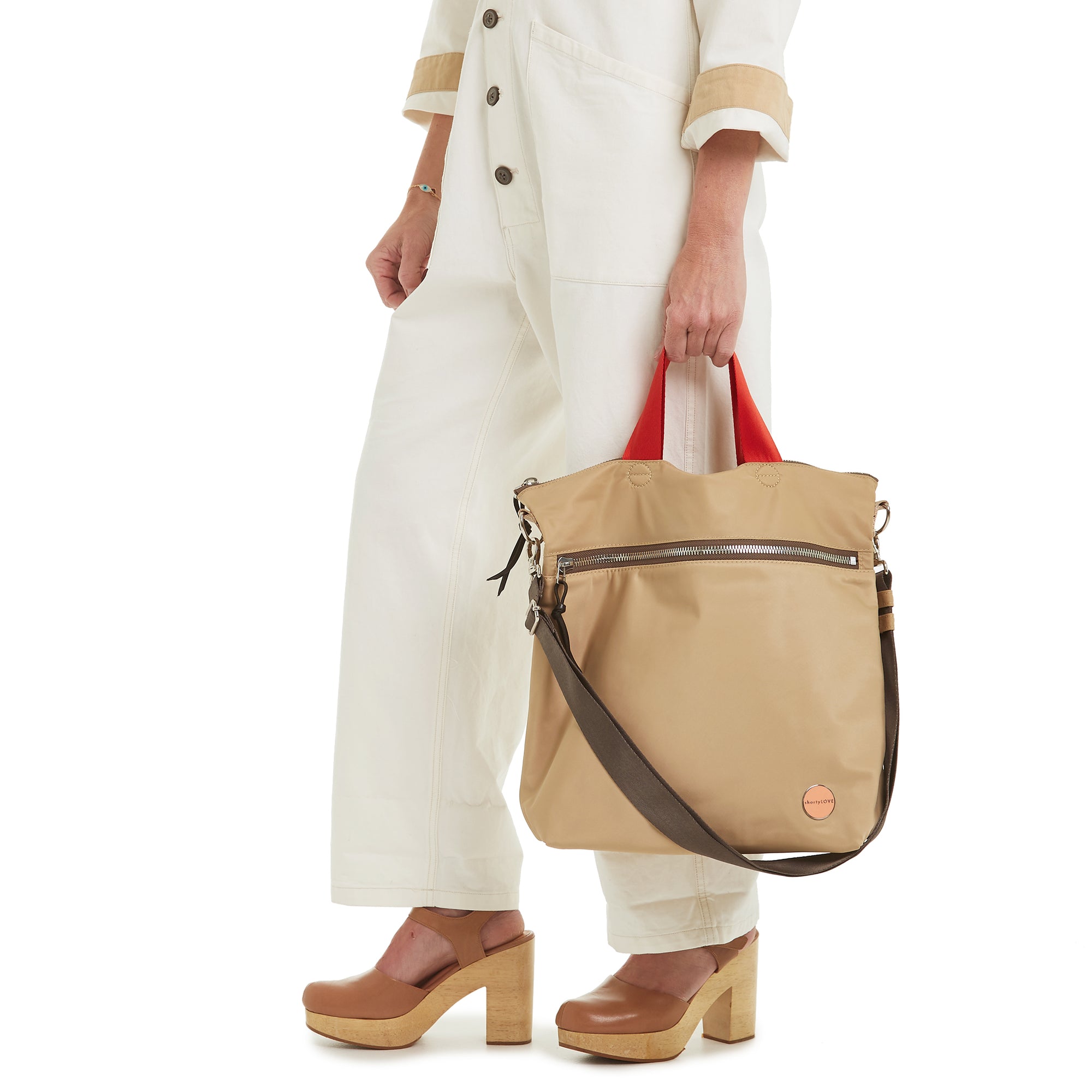 shortyLOVE wonder large crossbody/messenger bag in khaki; hand held by model in white jumper against white background.