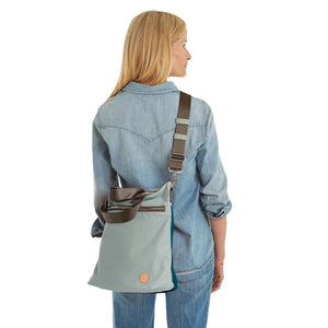 shortyLOVE wonder large crossbody/messenger bag in slate/teal; on model in  jean shirt and jeans against white background.