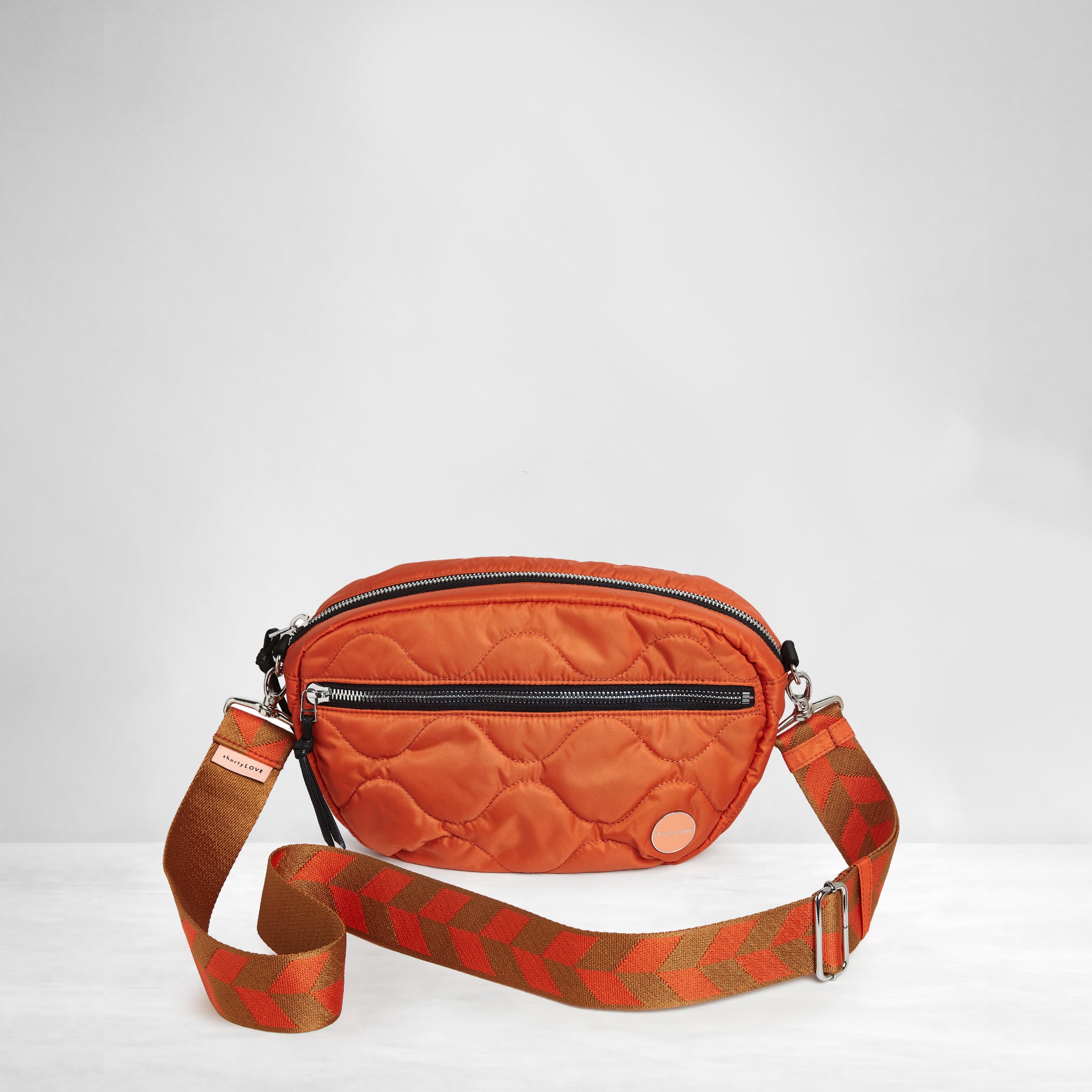 shortyLOVE boardwalk strap in arrow design orange/tobacco; shown with small cruiser bag in orange.
