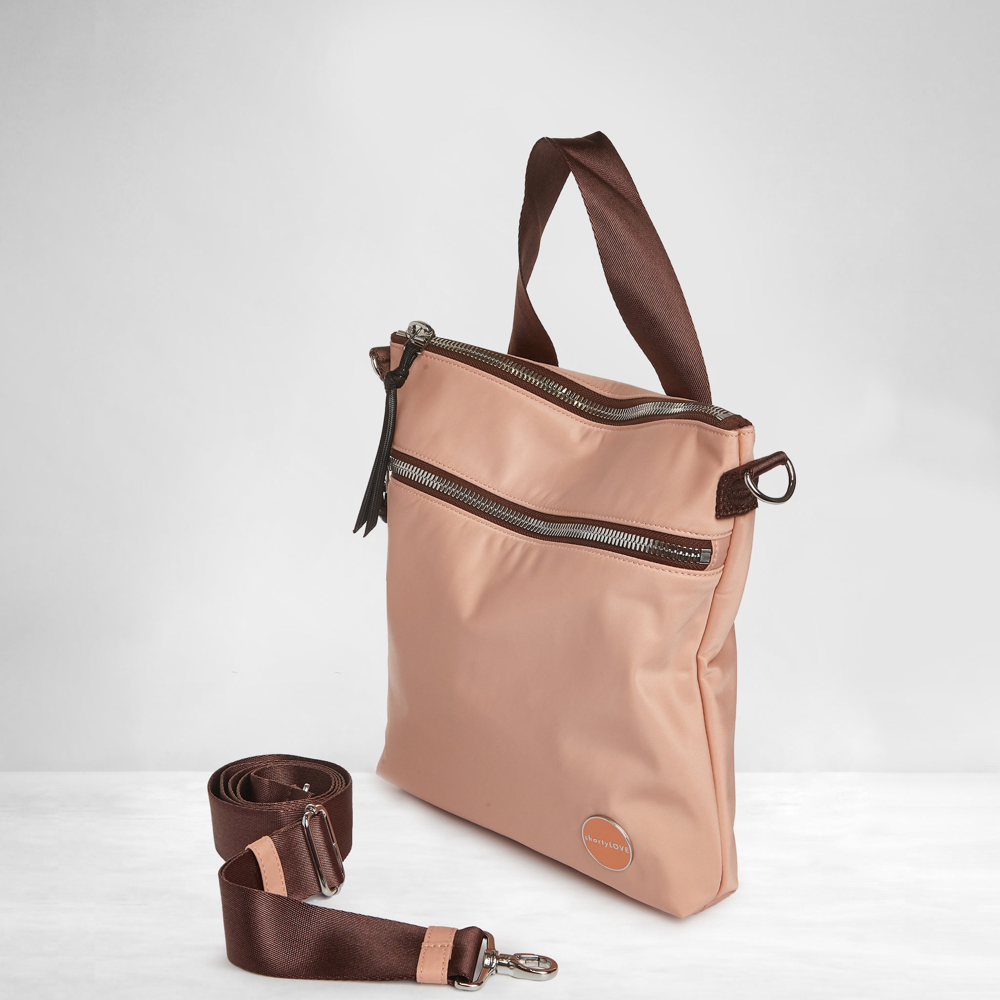 shortyLOVE amuse medium sized crossbody bag in dusty peach; side view against grey background.
