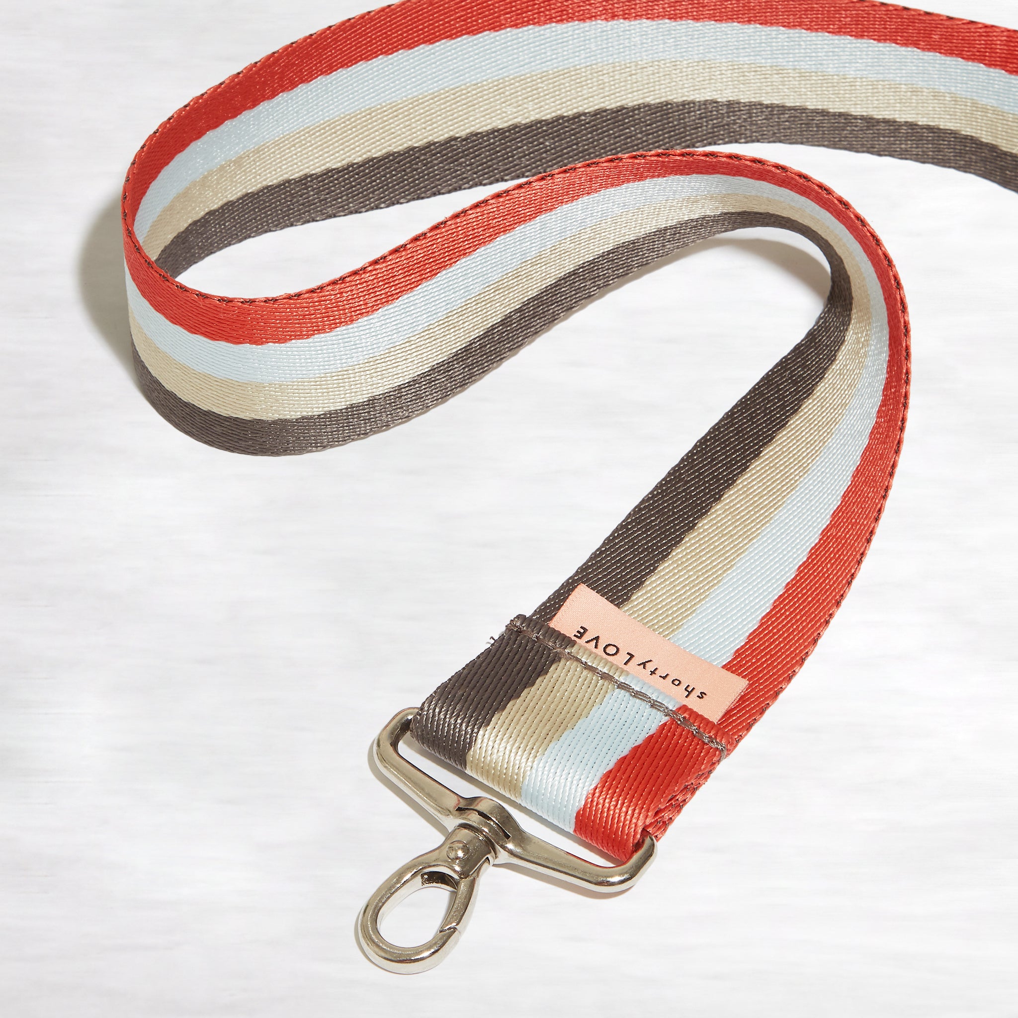 shortyLOVE boardwalk strap in mocha/khaki/blue/orange; front view rolled against white background.