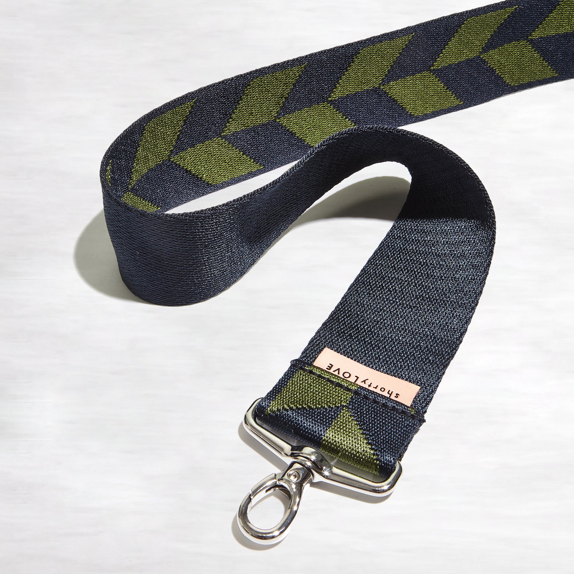 shortyLOVE boardwalk strap in arrow design in midnight/sage; top view front view rolled against white background.