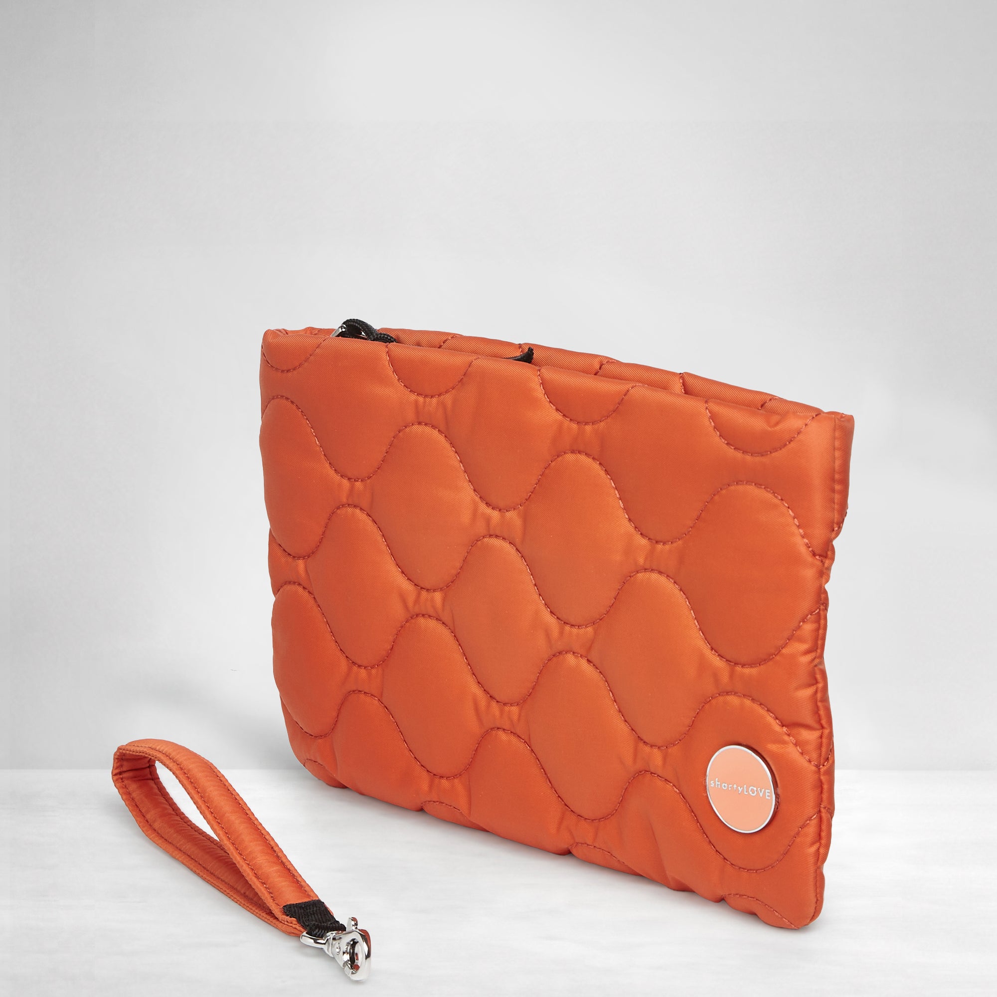 shortyLOVE cleo wristlet clutch in orange; side view against white background.