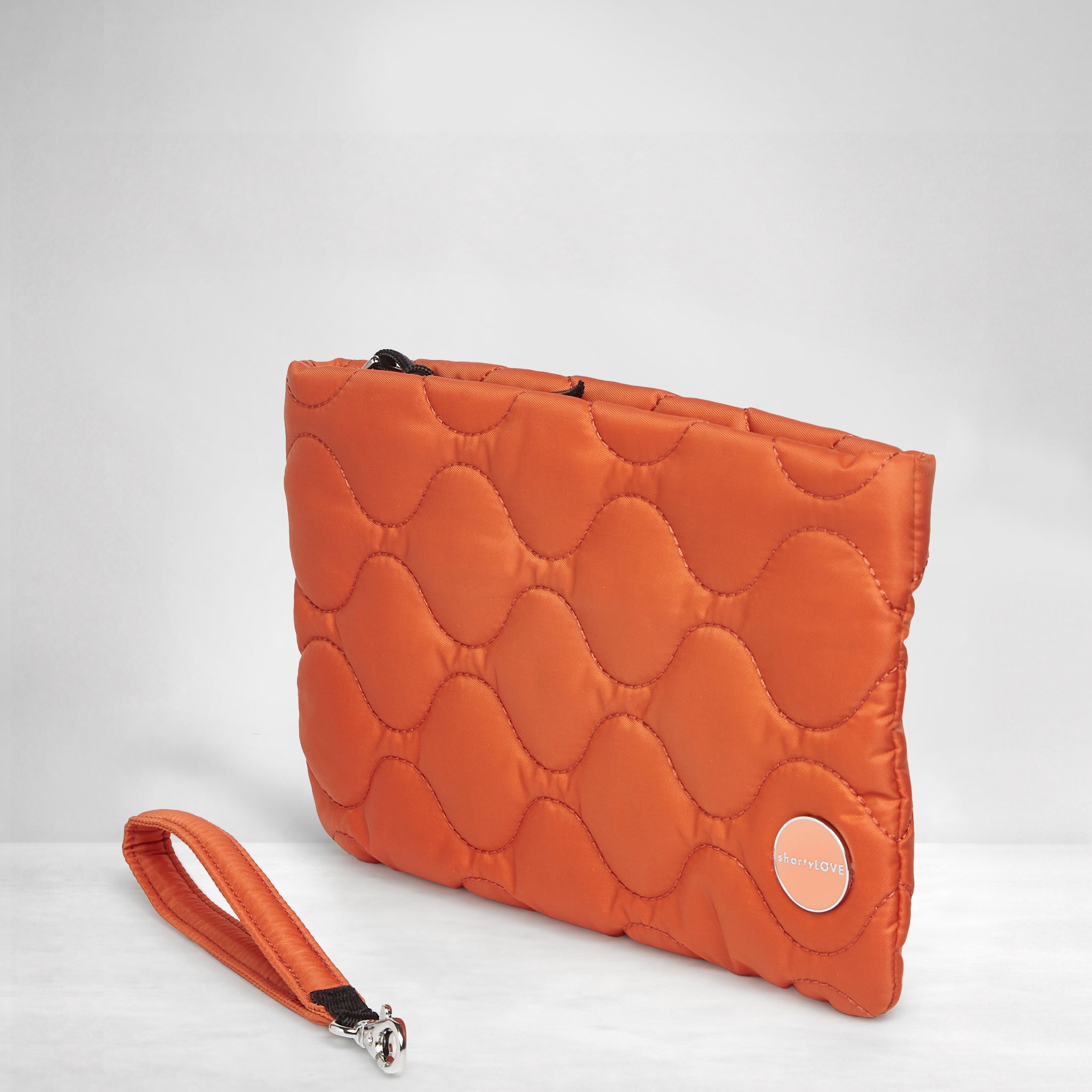 shortyLOVE cleo wristlet clutch in orange; side view against white background.