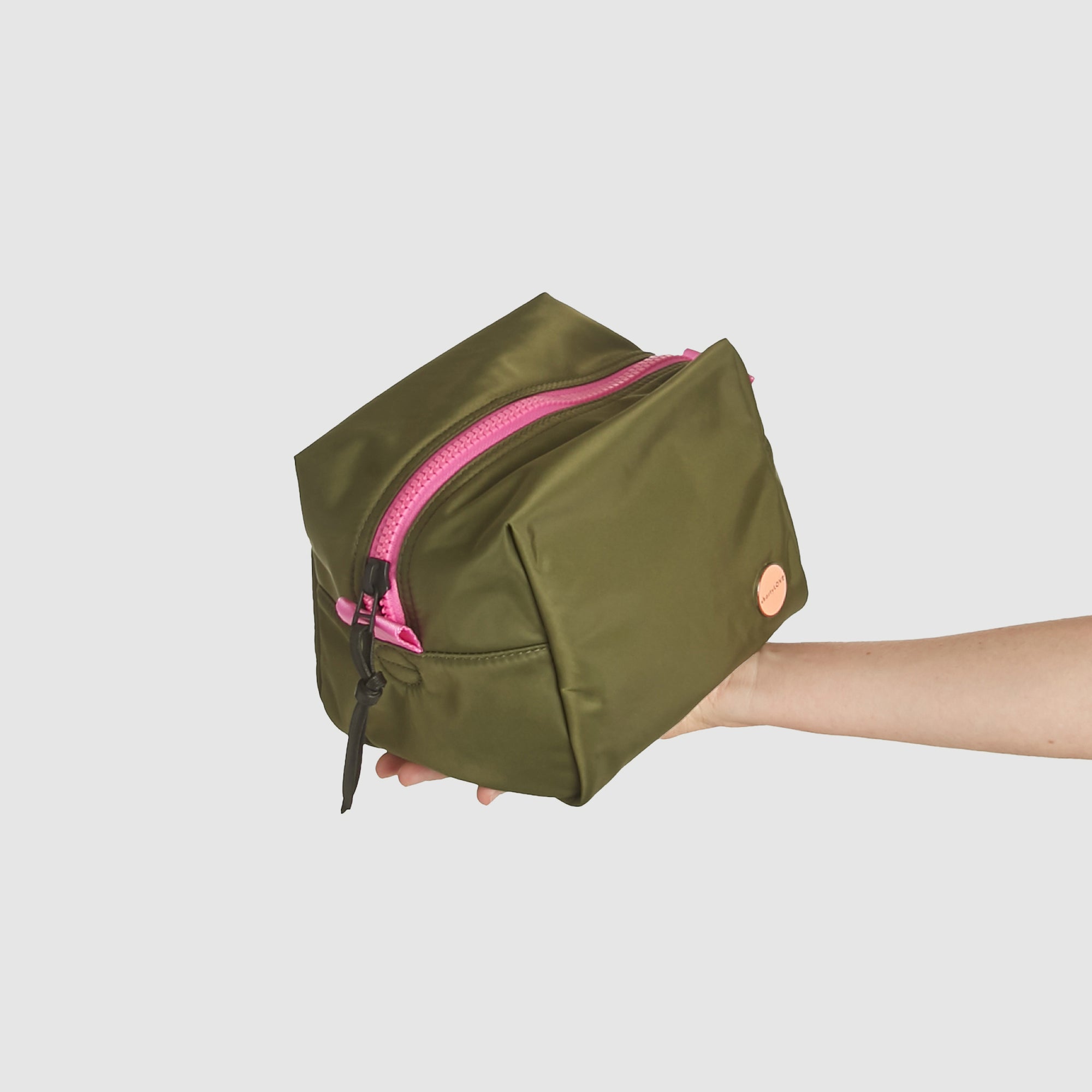 shortyLOVE stevie cosmetic bag in army green; hand held by model.