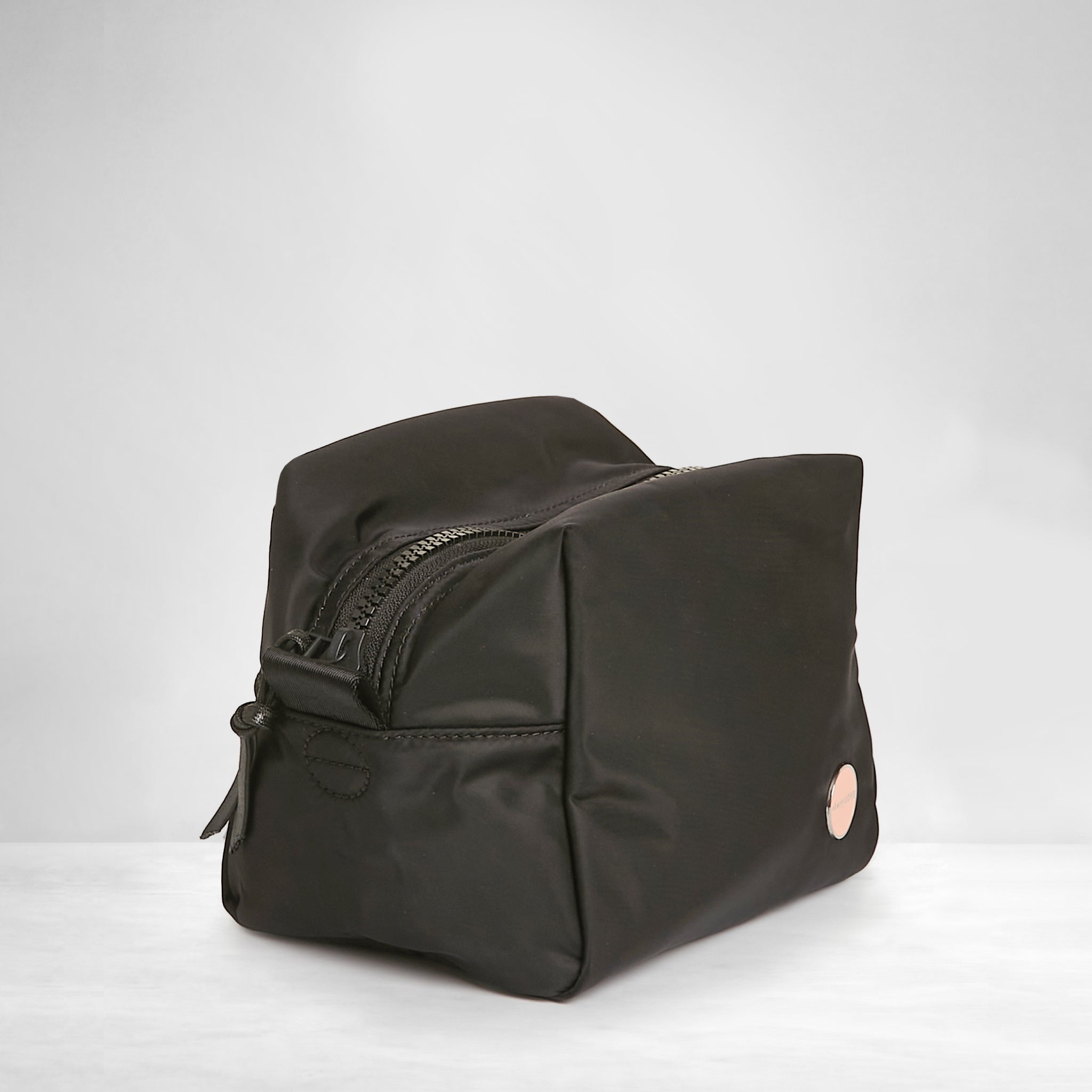shortyLOVE stevie cosmetic bag in black; side angle view against white background.