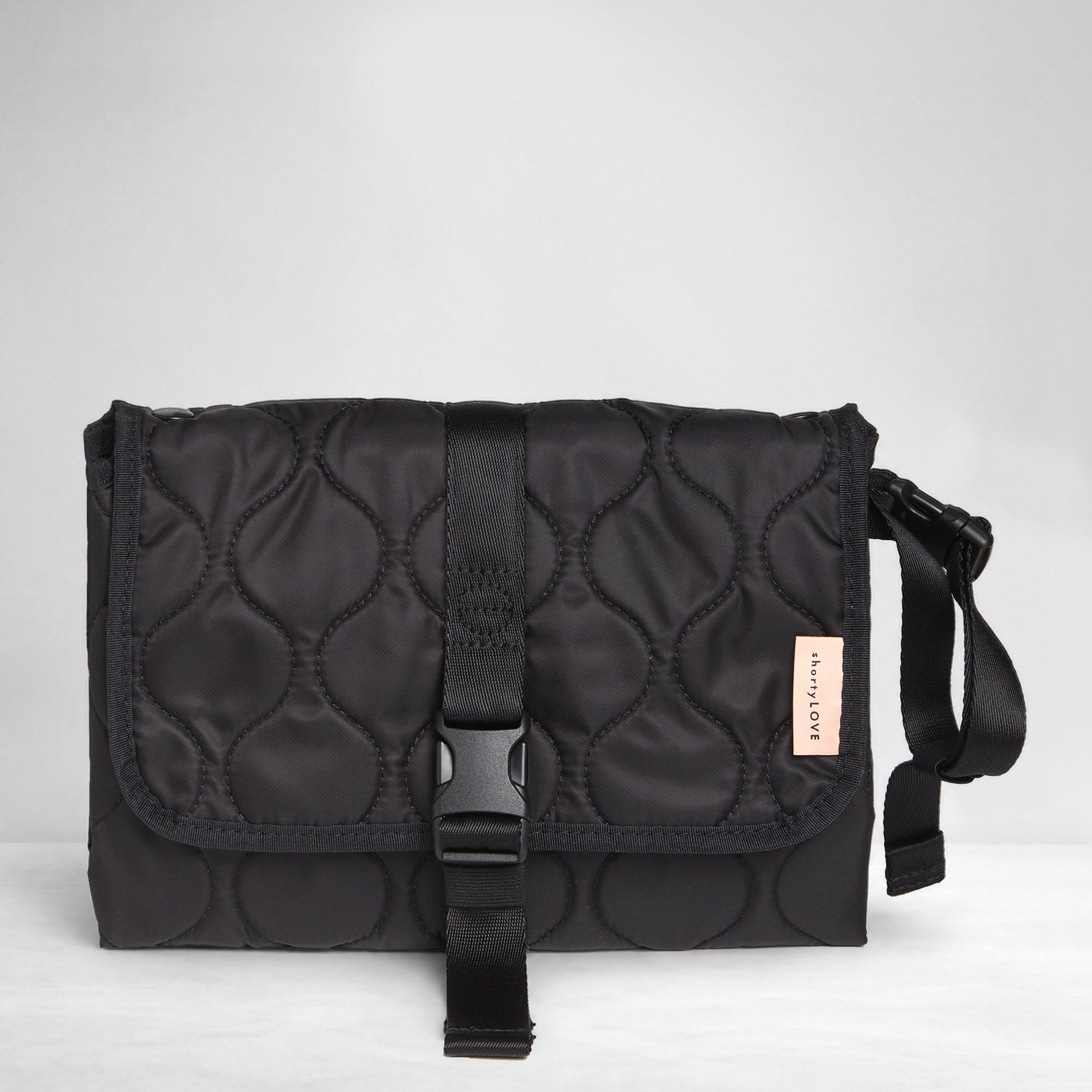 Black quilted diaper changing mat folded and closed - front view on a white background