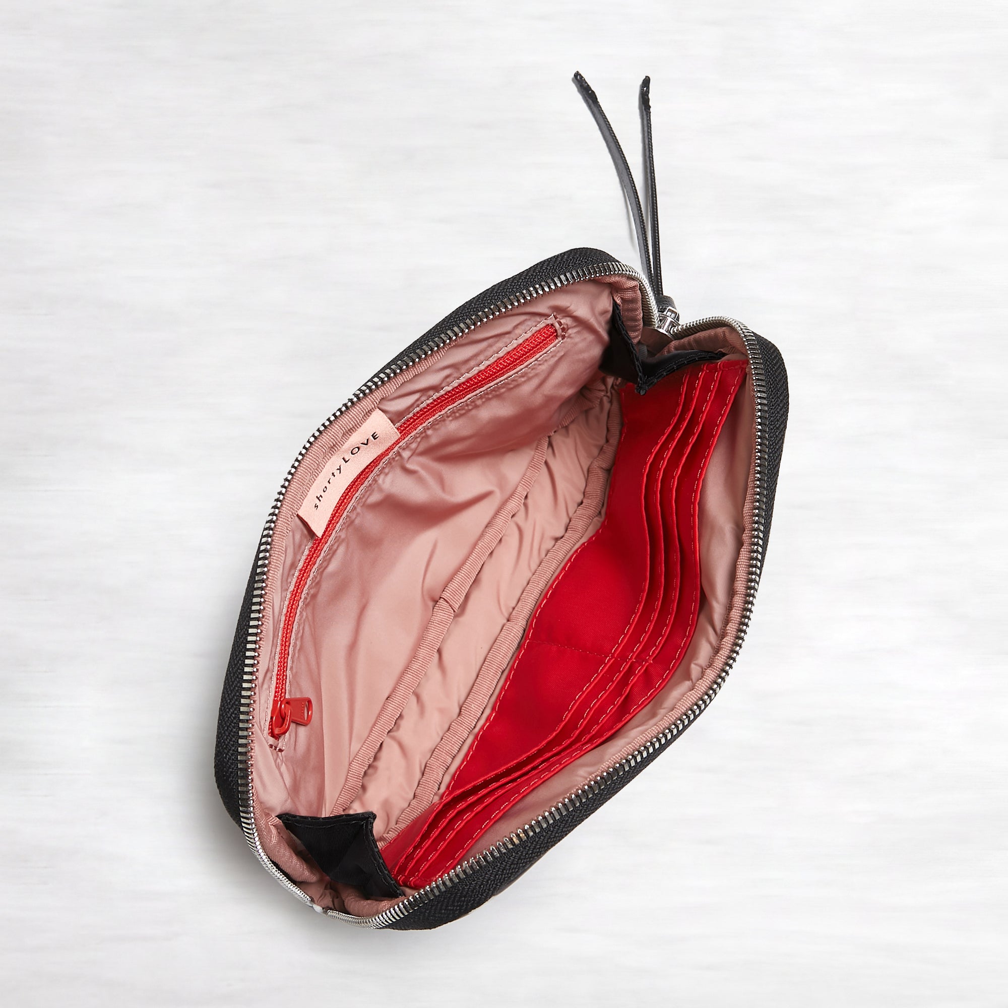 shortyLOVE jetty clutch/wallet in black; top-down view showing interior pink lining against white background.