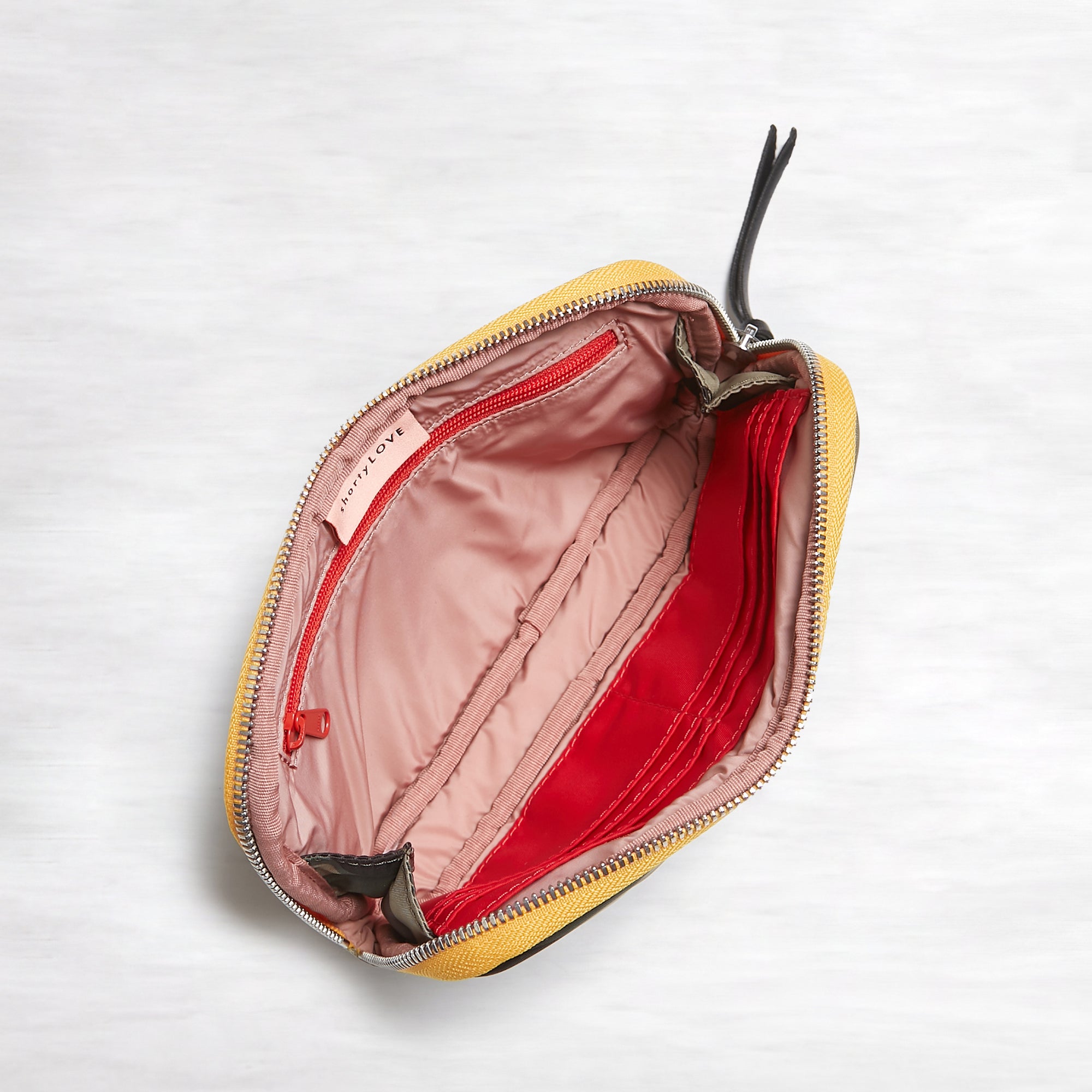 shortyLOVE jetty clutch/wallet in green camo; top-down view showing interior pink lining against white background.