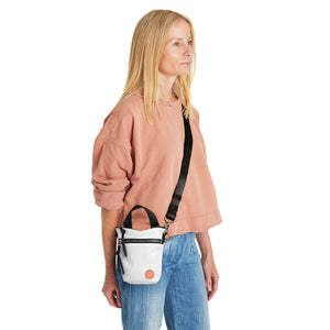 shortyLOVE shorthand small crossbody bag in white; on model in peach sweatshirt and jeans against white background.