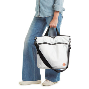 shortyLOVE wonder large crossbody/messenger bag in white; hand held by model in jeans against white background.