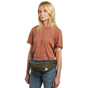 shortyLOVE arcade belt bag in army green; on model in rust t-shirt and jeans against white background.