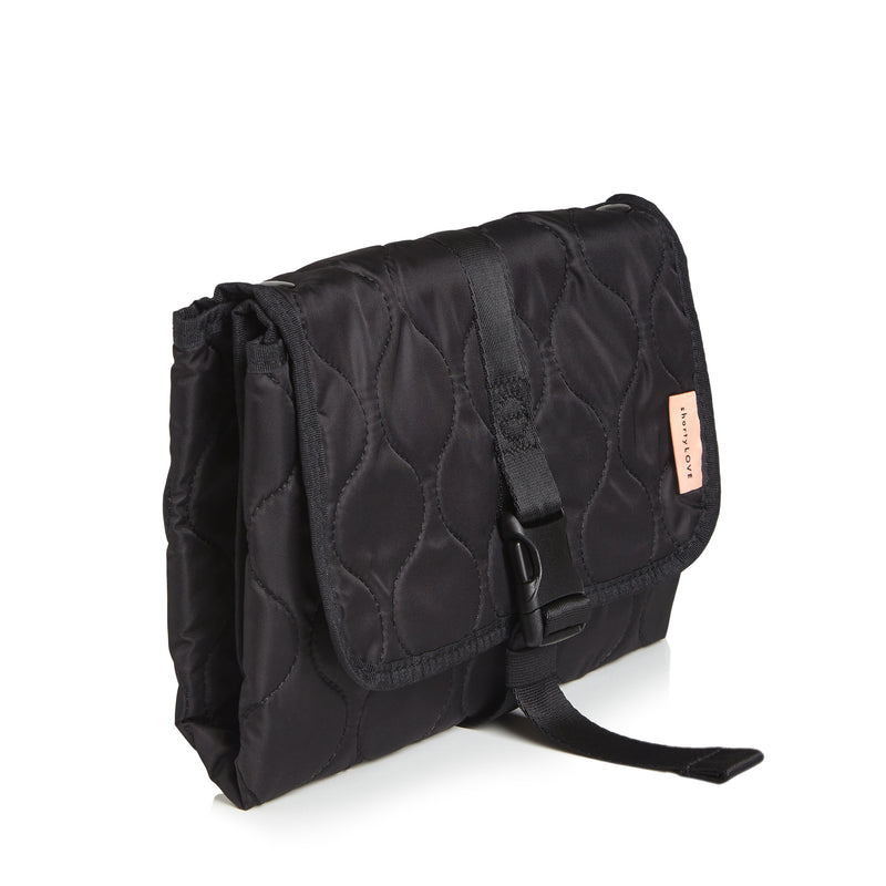 Black quilted diaper changing mat folded and closed - side view on a white background