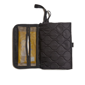 Black quilted diaper changing mat partially opened - top-down view on a white background