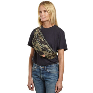 shortyLOVE arcade belt bag in green camo; on model in black t-shirt and jeans against white background.