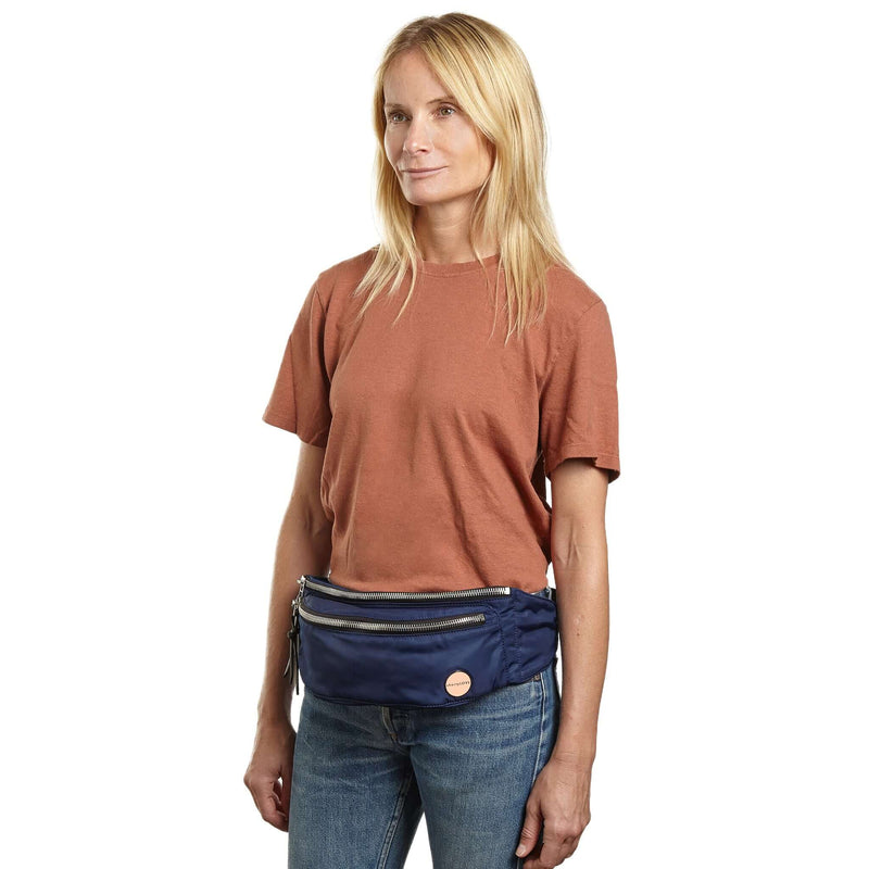 shortyLOVE arcade belt bag in navy; on model in rust t-shirt and jeans against white background.