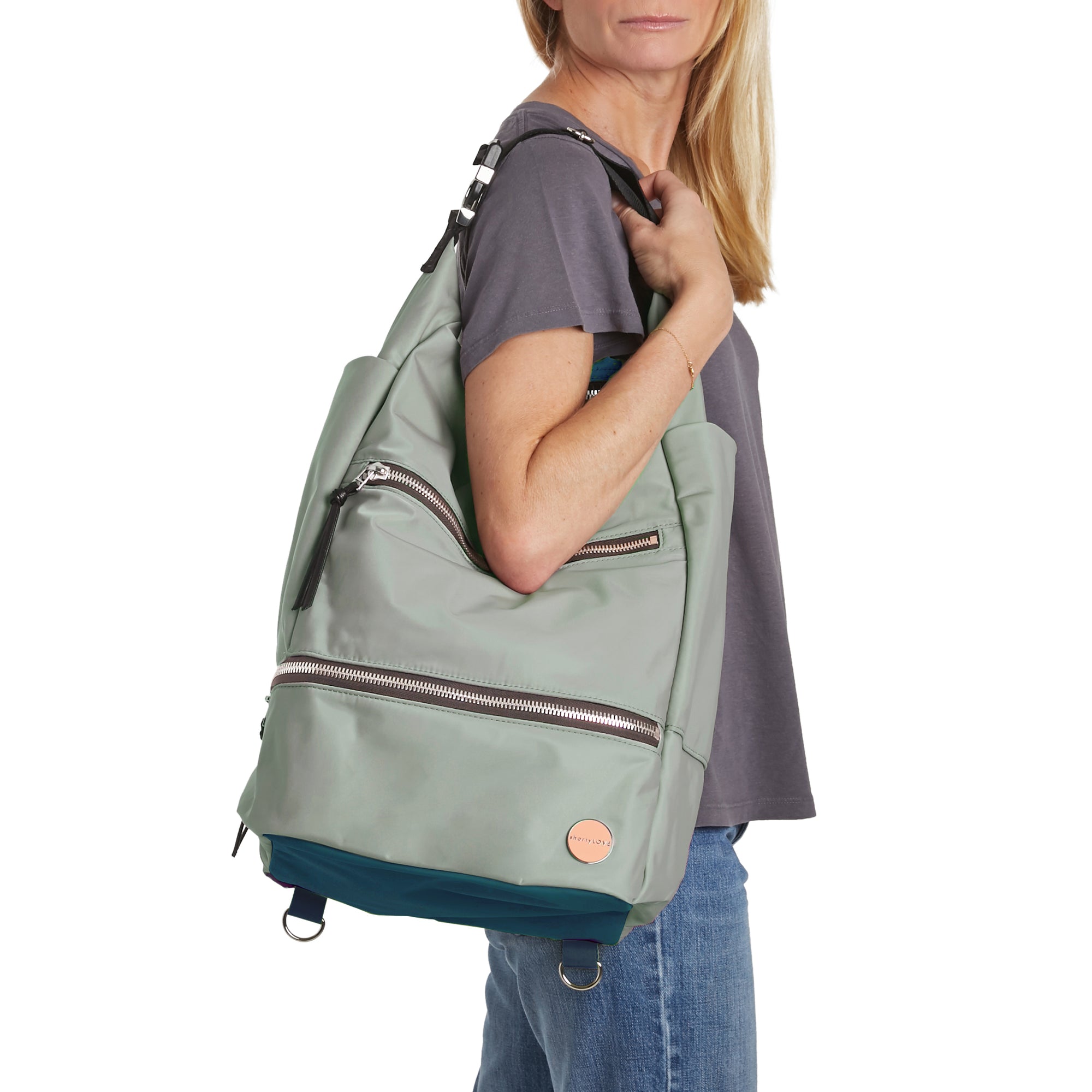 shortyLOVE boxer backpack in slate/teal; on model over shoulder in grey t-shirt and jeans against white background.