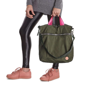 shortyLOVE wonder large crossbody/messenger bag in army green; hand held by model in grey long sleeve sweater and black leggings against white background.