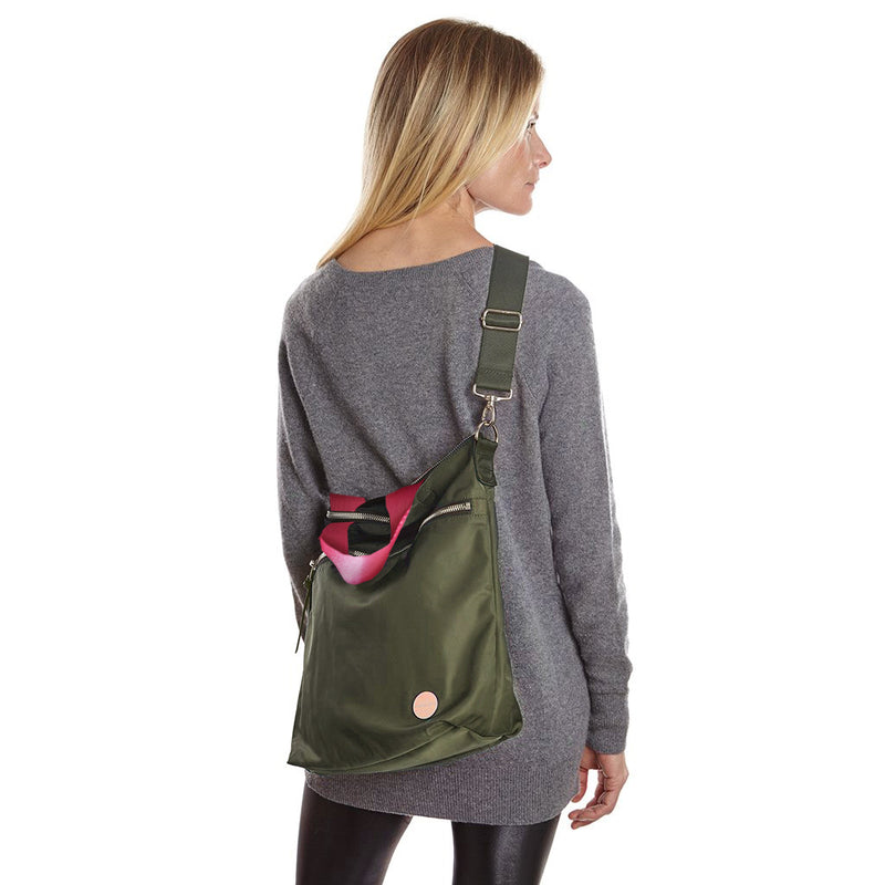 shortyLOVE wonder large crossbody/messenger bag in army green; on model in grey long sleeve sweater and black leggings against white background.