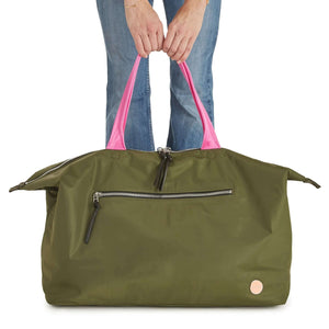 shortyLOVE friday weekender travel bag in army green; hand held by model in jeans against white background.