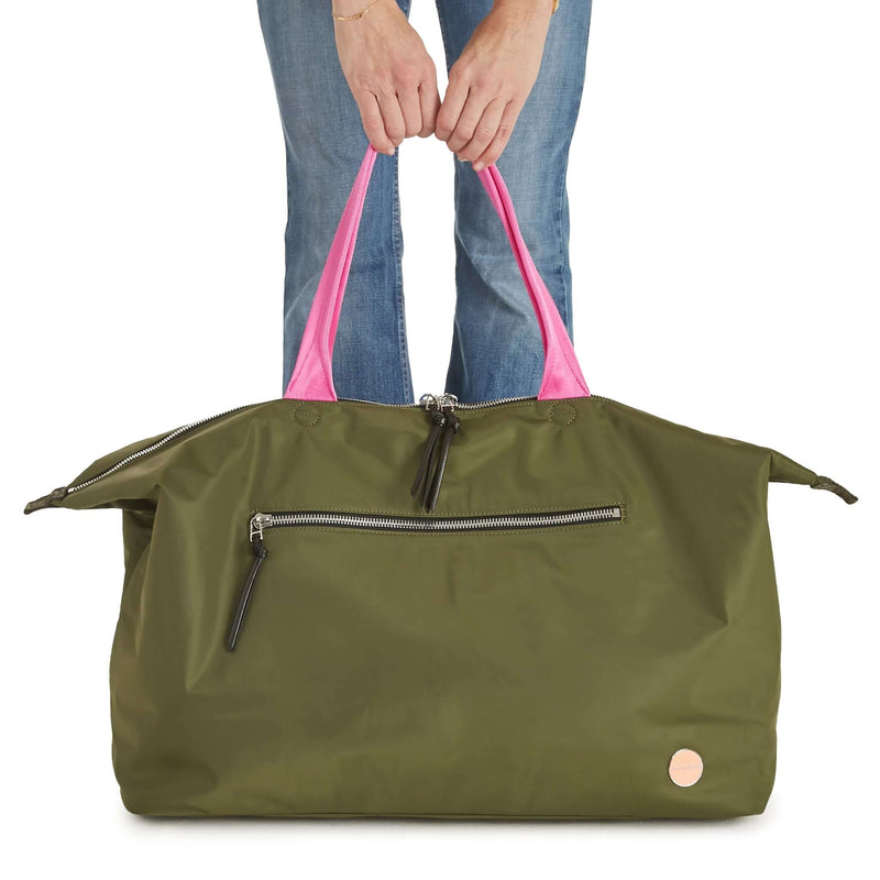shortyLOVE friday weekender travel bag in army green; hand held by model in jeans against white background.